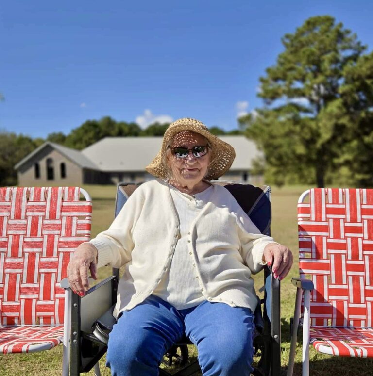 Elderly woman sitting outside in a lawn chair