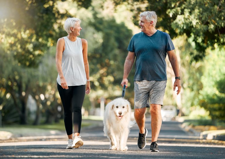 Middle aged active couple walking their dog